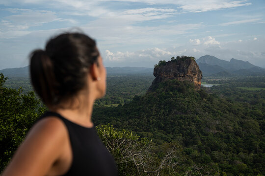 Woman admiring Lion Rock Sigiriya in lush Sri Lankan landscape