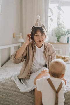 Parent and child celebrate first birthday and first steps indoors