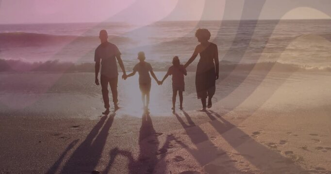 Parents holding children's hands stepping into wet sand, sun casting long shadows, travel marketing