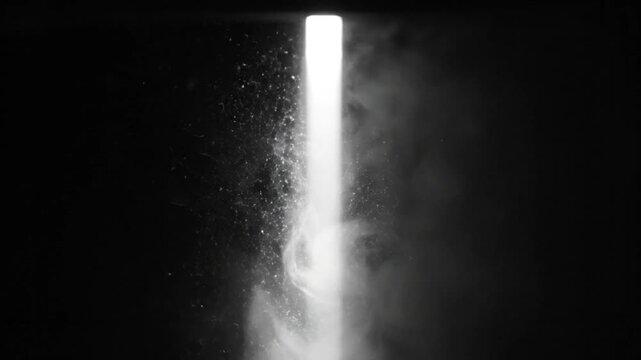 Bright light shining down from a rectangle opening surrounded by darkness with wispy smoke drifting