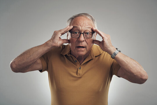 Portrait, shocked and old man in studio, omg and announcement on gray background. Retirement, wow or senior person with facial expression, reaction for fake news or surprise for info, secret or emoji