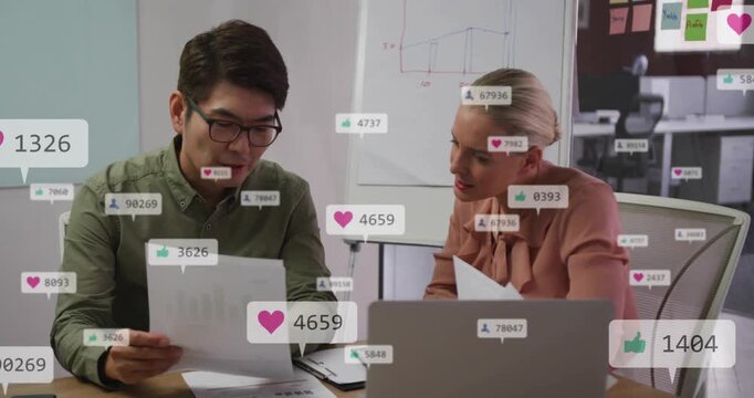 Business team reviewing data man flipping pages woman viewing laptop reaction icons rising fading