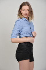 Fototapeta premium Junge Frau im bauchfreien Denim-Outfit, skinny Figur und lässiger Look, nachdenkliche Pose, modernes Fashion- und Lifestyle-Porträt