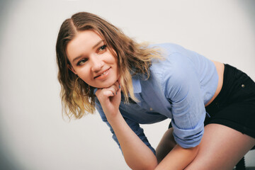 Fototapeta premium Junge Frau im bauchfreien Denim-Outfit, skinny Figur und lässiger Look, nachdenkliche Pose, modernes Fashion- und Lifestyle-Porträt