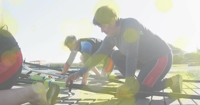 Launch preparation starting with foreground kneeling rower securing oars, readying shell for launch