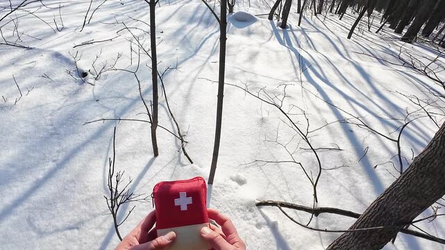 Solo Explorer Skillfully Stows First Aid Kit Into Bright Backpack On Snowy Path. Hiker In Solitude Carefully Plants Emergency Medical Kit Into Vivid Bag During Wintery Trekking Expedition