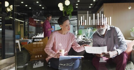 Reviewing pink-sweater woman and man comparing charts, checking laptop in office with glass graphs