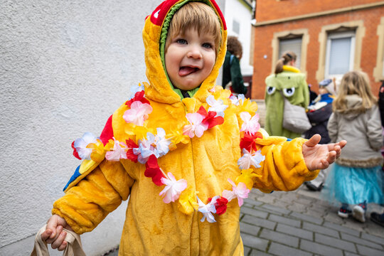 Child in colorful costume celebrating German carnival outdoors
