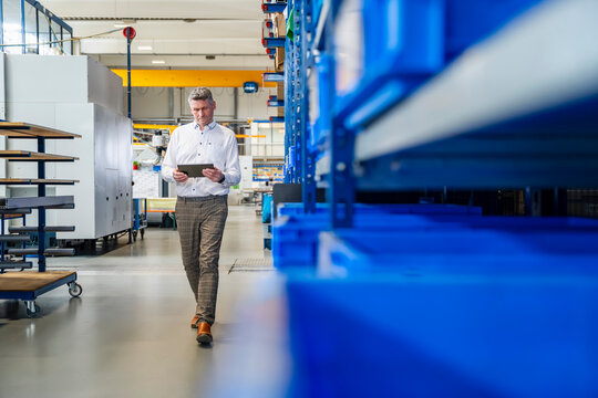 Business manager with tablet in modern industry production hall