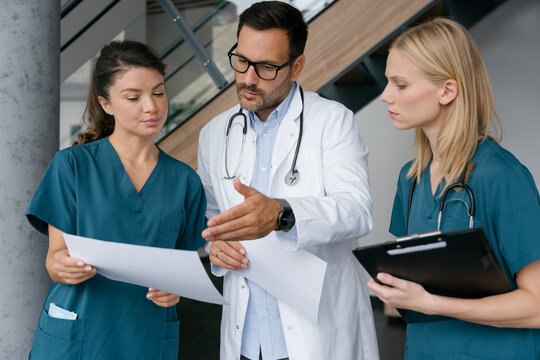 Doctor and nurse discussing medical documents at hospital