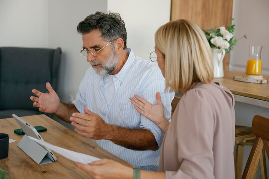 Couple discussing financial problems with bills at home