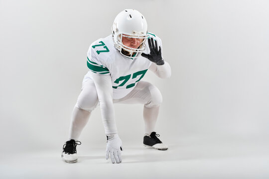 American football player in full gear posing in defensive stance