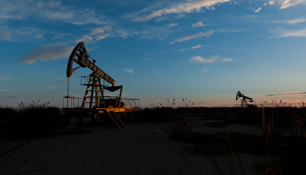 Oil pumpjack silhouetted against blue sky at dusk outdoors