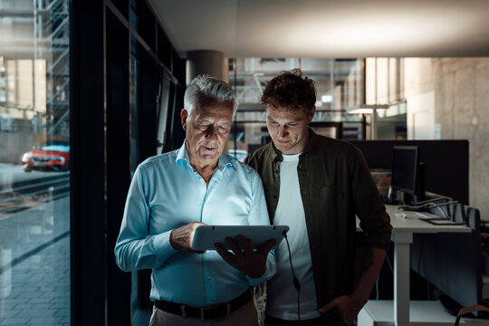 Colleagues collaborating in a modern office with digital tablet