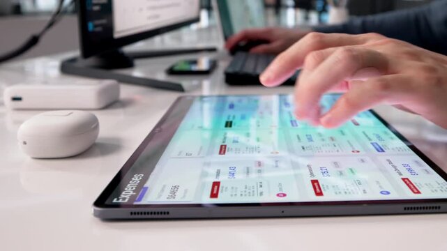 Financial Analyst Reviews Expense Reports On Tablet
