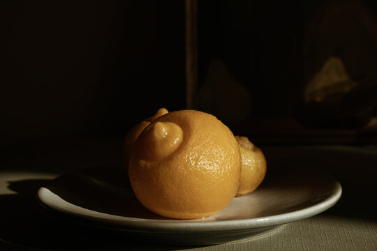 Preserved lemon on a dish in warm light with dramatic shadow