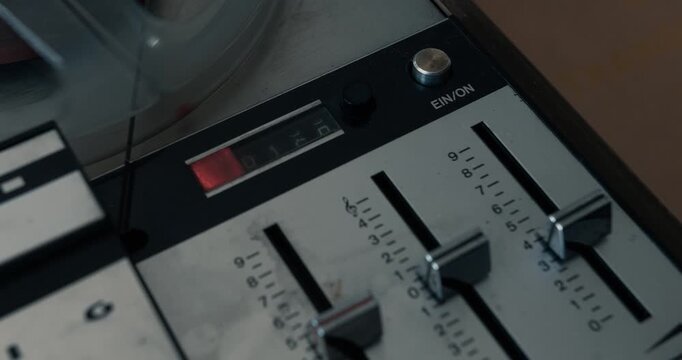 Close-up of a vintage tape recorder playing an old tape in dim light