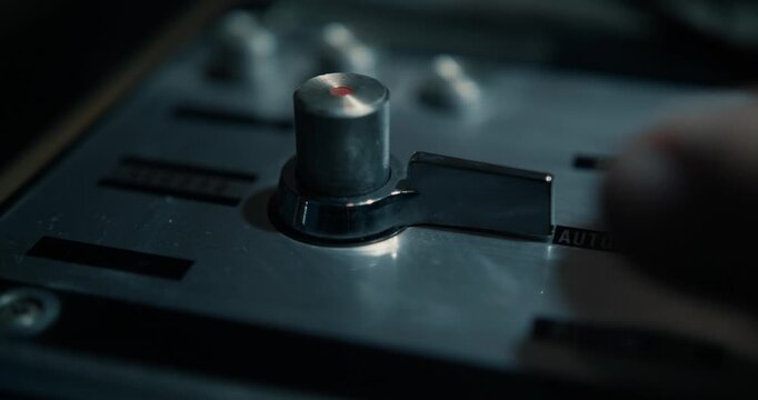 Hand turning vintage tape recorder switches