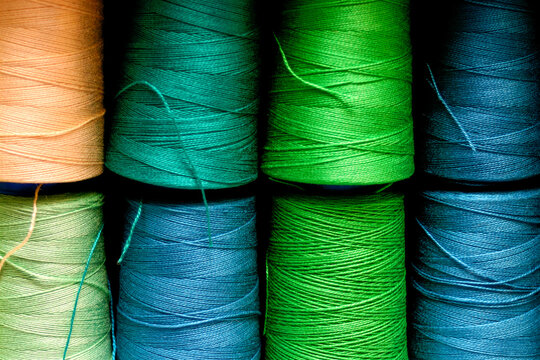Colorful Thread Spools Background with Vertical Textile Pattern