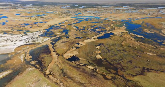 4K video; slow backward drone flight over a wetland landscape with rivers and lakes on the pampas in the vicinity of the village of Gobernador Gregores, Santa Cruz Province Argentina