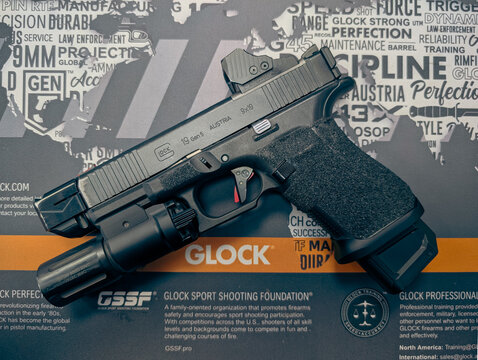 BALTIC STATES &ndash; APRIL 10, 2026: A customized Glock 19 Gen 5 tactical pistol featuring a Shield Sights RMSw optic, Modlite weapon light, and compensator.