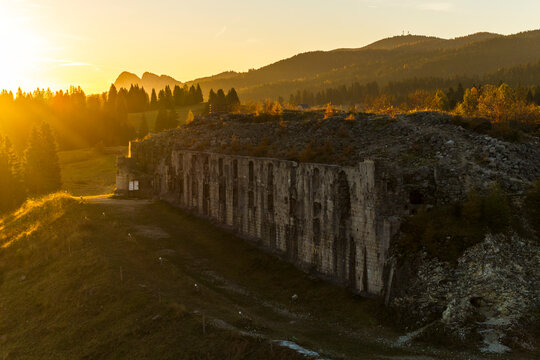 First World war,Cherle Fort,Trentino,Italy. Ancient fort ruins stand against a backdrop of forested mountains at sunset, a travel destination.