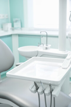 Dental tray and instruments on chair in a bright modern dental operatory