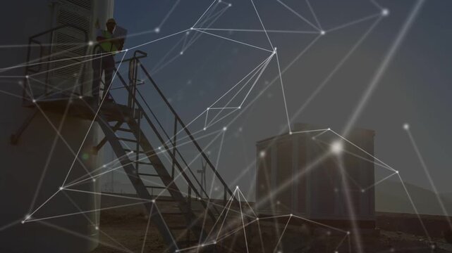 Network overlay drifting revealing tech climbing turbine stairs doing maintenance checks with radio