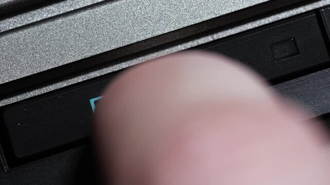 Black player button with blue text being pressed in macro close up