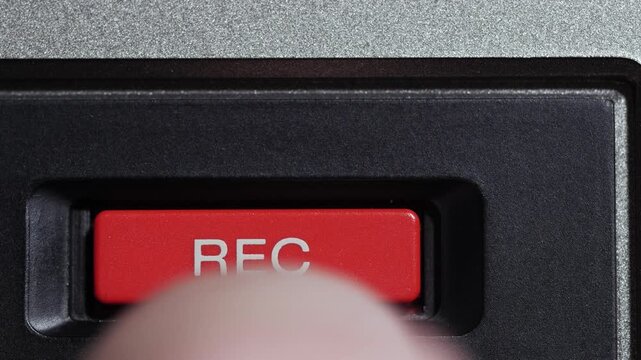 Finger presses red REC button with white text on vintage video controller