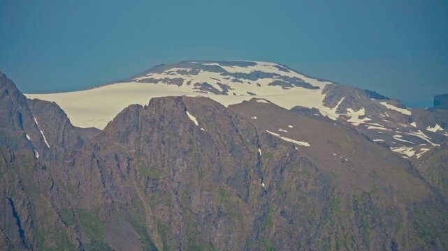 Middagsfjellet, Sandland, Nordkapp, Finnmark, Norway - The Majestic Mountain Peak, Covered in Snow, Rises Sharply Against the Clear Blue Sky - Close Up