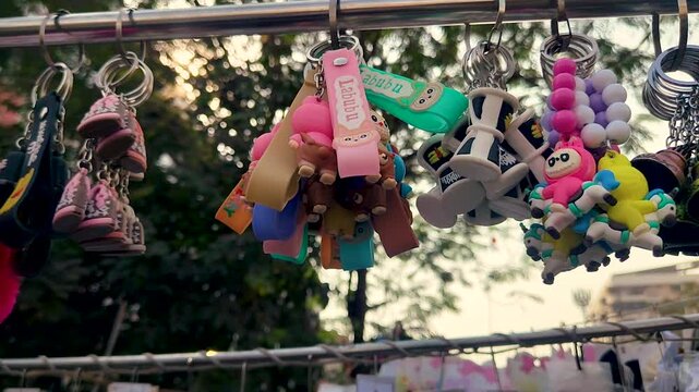 Vibrant keychains and playful charms displayed at local street market, perfect for souvenir and accessory buyers. Ideal for shopping, retail, and street lifestyle footage.