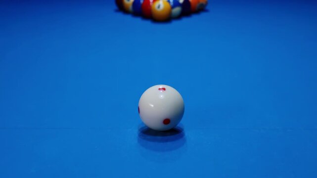 Coloured billiard balls arranged neatly racked in triangle formation blue felt pool table ready to play game of snooker, white cue ball wait ready for opening start first break shot, leisure strategy