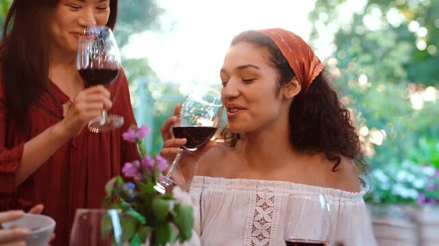 Smile, friends and hug with red wine outdoor for greeting, celebration and lunch reunion. Women, embrace and cheers with alcohol for social gathering, hangout together and gratitude of Easter holiday