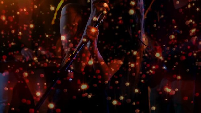 Camera revealing female singer holding retro mic, singing and performing music for crowd bokeh