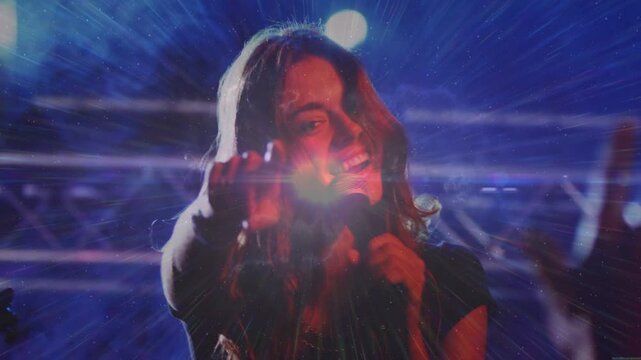Lead singer stepping at concert camera moving singing and reaching audience with mic and flare