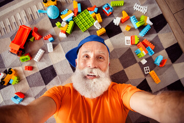 Playful grandpa selfie moment with lego blocks at home smiling and relaxed on weekend fun © deagreez