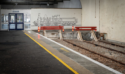 Buffers at the end of the line and Steam Train Mural beside the way out sign at Thurso, Scottish Highlands,  Caithness,  Scotland, UK