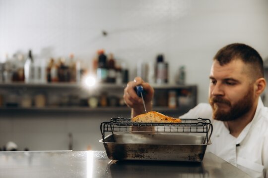 Chef measuring salmon temperature during cooking process