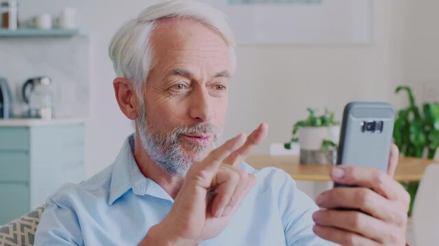 Smartphone, wave and happy man with video call in home, networking and sign language for communication. Virtual greeting, talking and mature person with love gesture for connection, mobile or contact