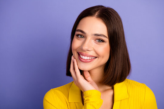 Young chic smiling brunette woman in yellow blouse posing against purple background for fashion lifestyle stock photo