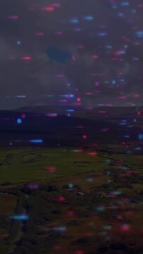 Vertical video: Valley farmland holding particle overlay appearing and shifting, growing for agtech