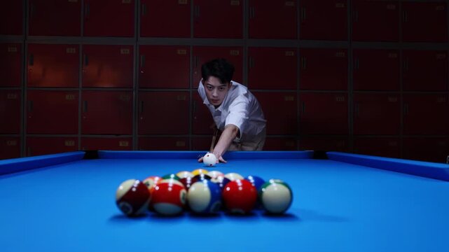 Billiard player with cue aiming at colorful balls opening spread on green pool table, man breaks pyramid of balls by hitting white ball with the cue, starts game with his first shot, hobby relax time