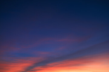 Fototapeta premium Bright orange and blue colored clouds on evening sky