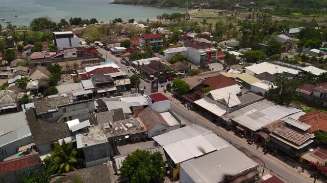 ropical coastal town with village rooftops winding streets palm trees and calm bay nearby everyday island settlement and shoreline practical layout of a growing coastal settlement