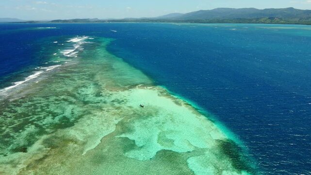 Aerial view of the coral reef and turquoise waters of cayo arena natural pool, Montecristi, Dominican republic, with distant mountains.