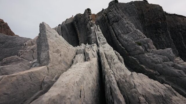 Low angle panning shot of flysch rock formations at La Arnia coast Cantabria Spain