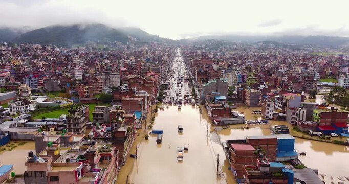 Drone shot of flooding in Banepa Nepal submerging buildings, trucks and vehicles, causing major blockade along the Araniko Highway due to monsoon overflow.