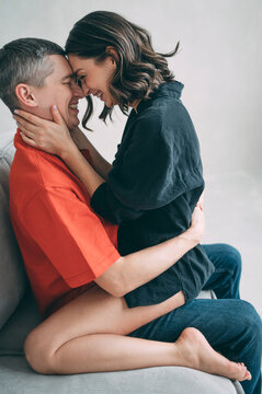 Happy couple embracing with affection indoors on a sofa