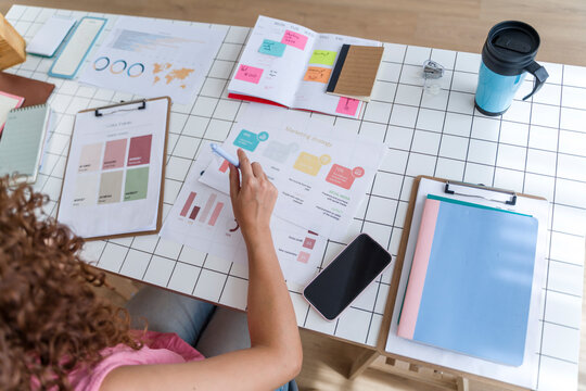 Creative marketing planning at office desk with statistics and reports